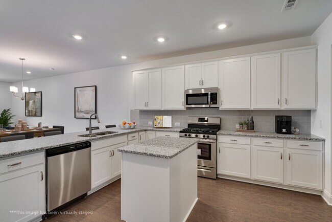 Kitchen looking into the LR and over the large breakfast bar. Staged Photo - 415 Alter Ter