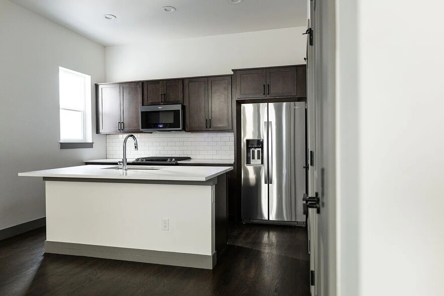 Full kitchen with stainless steel appliances, including a microwave, gas range, dishwasher, & fridge - 3505 S Marion St