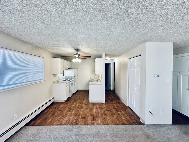 Experience modern living in this inviting kitchen and living area, perfect for relaxation and entertaining. - Hawk Point Apartments