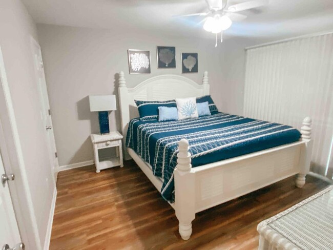 Primary Suite has attached bath, door to front porch, and a king size bed. - 505 Carolina Beach Ave N