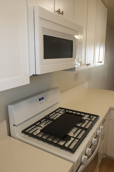 New range, microwave, quartz counter, and cabinets. - 426 Orange Blossom