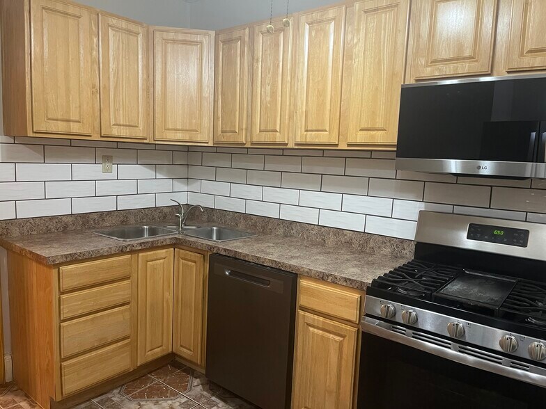 Kitchen has double sink and stainless steel range and refrigerator - 7619 S Phillips Ave