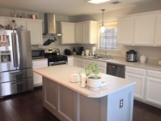 Kitchen other view, to stove, refrigerator, and sink with window view - wood floors - 3809 Willie Mays Ln