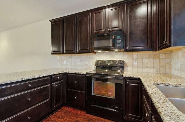 state of the art kitchen with black appliances - Tinsley Place