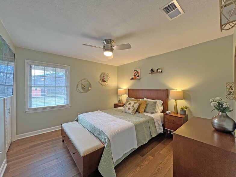 Queen bedroom featuring a 55" smart TV w/Roku, ceiling fan w/remote & comfortable dual bedside light - 160 17th Street Pl NW