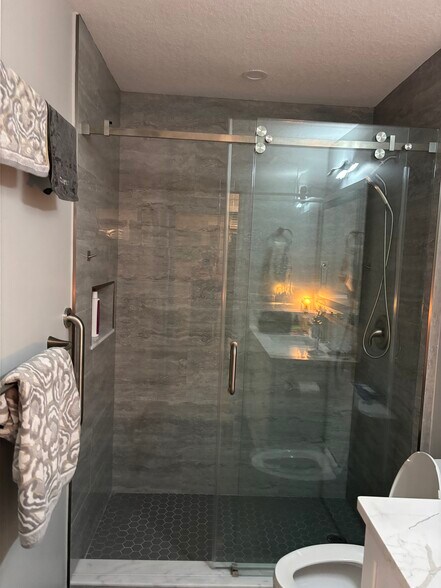 Guest bathroom, porcelain tile with barn door glass doors - 10 Vista Palm Ln