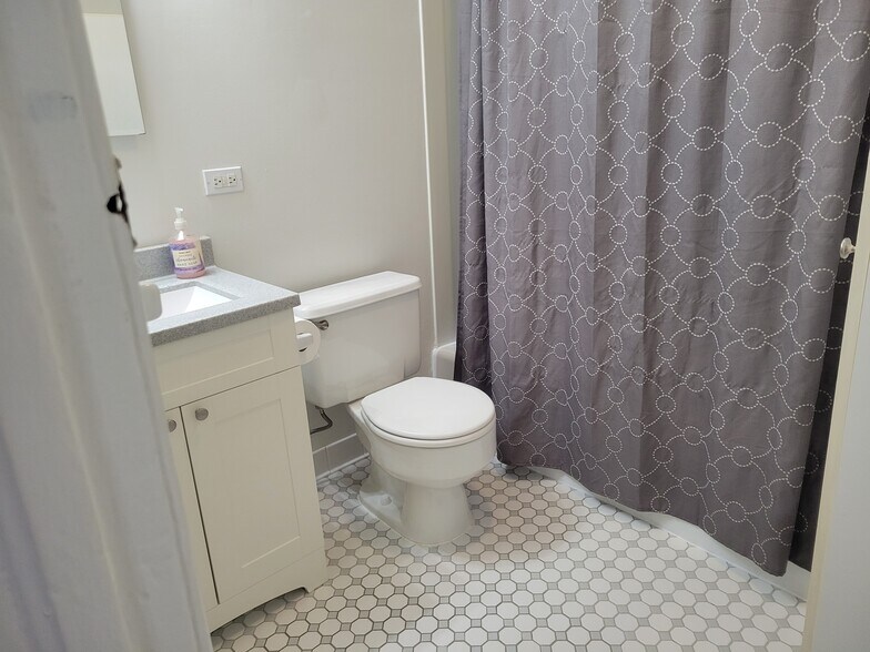 Bathroom with tiled floor and tub/shower. - 2527 N Marshfield Ave