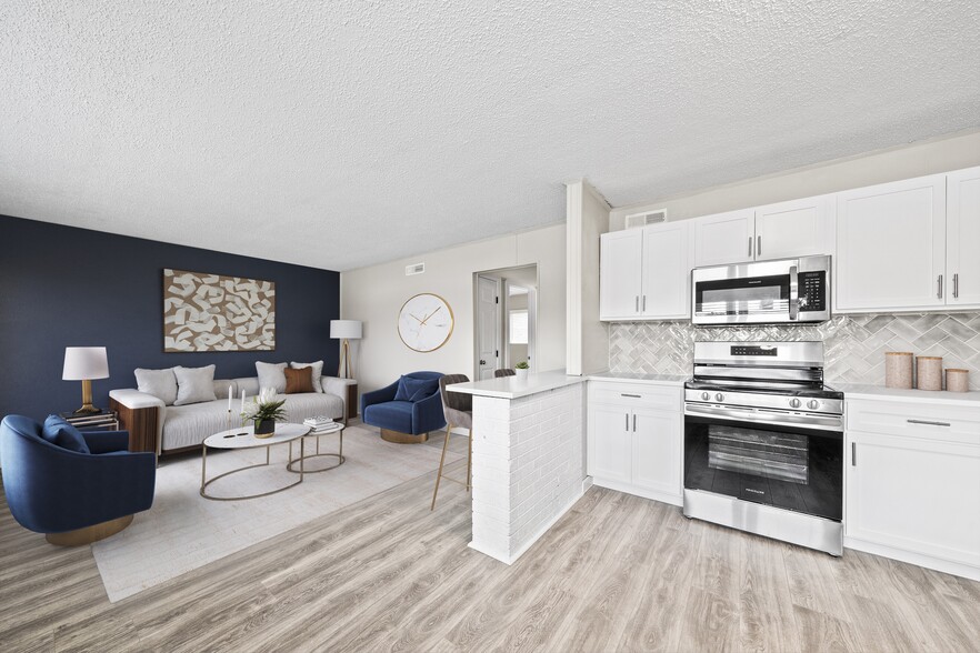 Cook and entertain in a newly renovated kitchen with sleek black appliances and modern finishes. - The Lynx Townhomes and Apartments