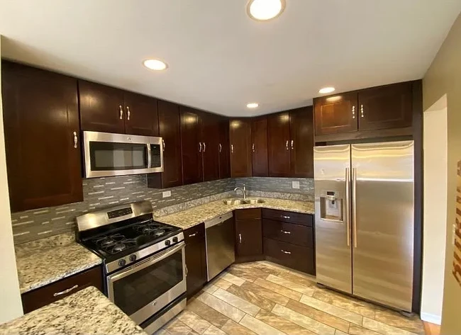 Updated kitchen features 42" cabinets, stainless steel appliances, granite tops, breakfast bar - 940 E Old Willow Rd