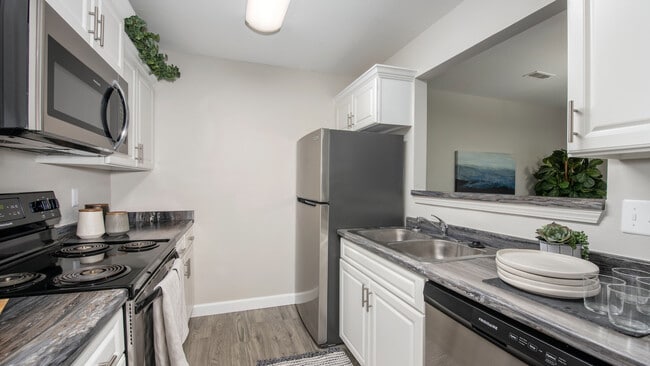 Cook with ease in kitchens featuring stainless steel refrigerators and black stove top ovens, professionally operated by Highlands Vista Group. - Atlas North