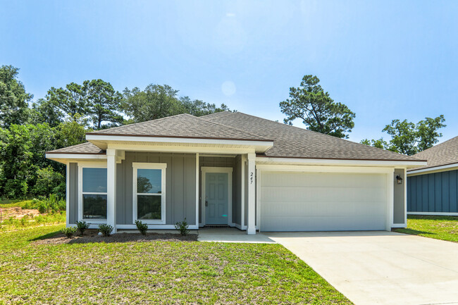 the front of a house with a driveway and a garage door - Cottages at Parkstone