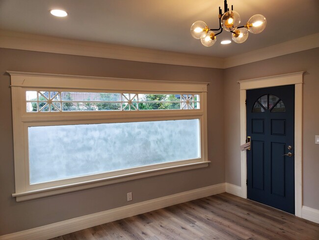 Living room with panoramic window with frosted glass for privacy, recessed lights and signature light fixture - 579 W. 13th St