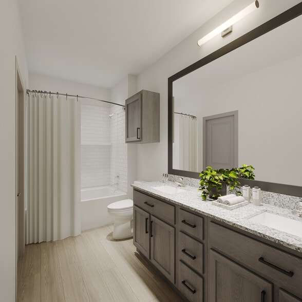 Modern Oakwood Trails bathroom with a large mirror, sleek vanity, and bright lighting for a fresh, contemporary look. - Oakwood Trails - A 62+ Community