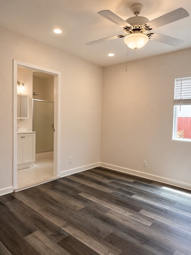 Floors are light Grey wood, Entrance to primary Bathroom from Primary Bedroom. - 4534 Edgewood Pl