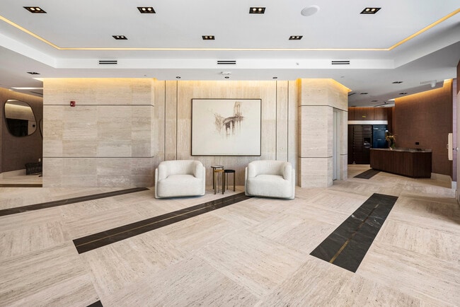 Grand lobby with travertine flooring, walnut paneling, and designer lighting - 701 Valencia