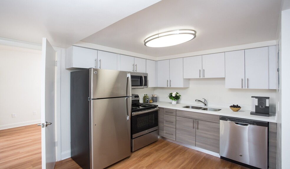 Renovated kitchen with quartz countertops and stainless steel appliances - Four Quarters