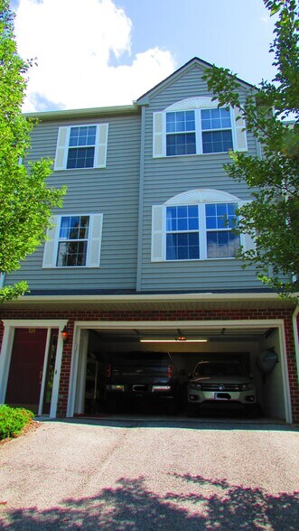 Front of unit. Full size pickup and SUV shown in the garage. - 720 Oaktree Blvd