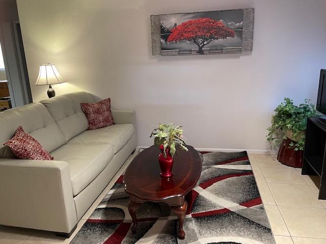 Living area with TV and large leather couch - 5921 E Boston St