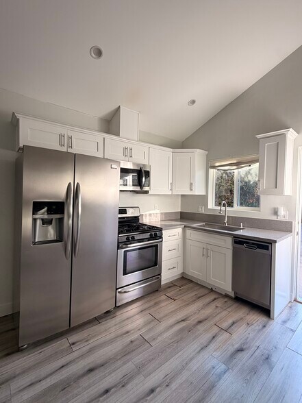 Kitchen with refrigerator, dishwasher, microwave, and stove - 20806 Skouras Dr