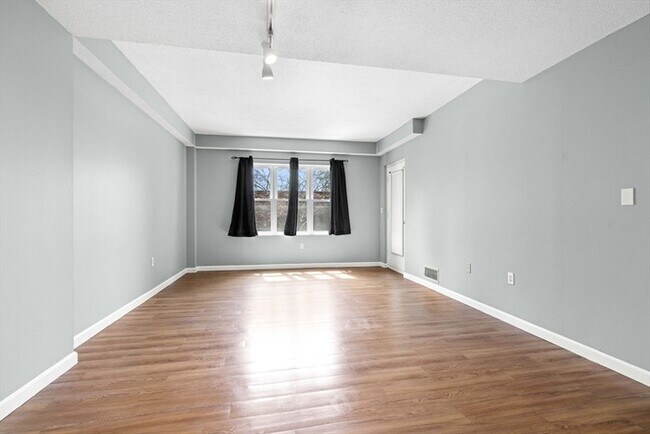 Building Photo - Updated 1BR Condo with Balcony, Garage Parking & Storage Near Commuter Rail