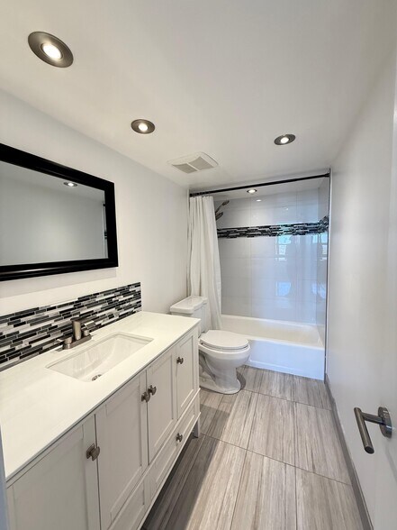Main Bathroom with a bathtub - 780 NE 69th St