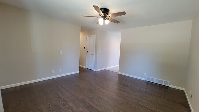 Large Living Room with refinished hardwood floors through the first floor. New ceiling fan & drapes - 6305 49th Ave