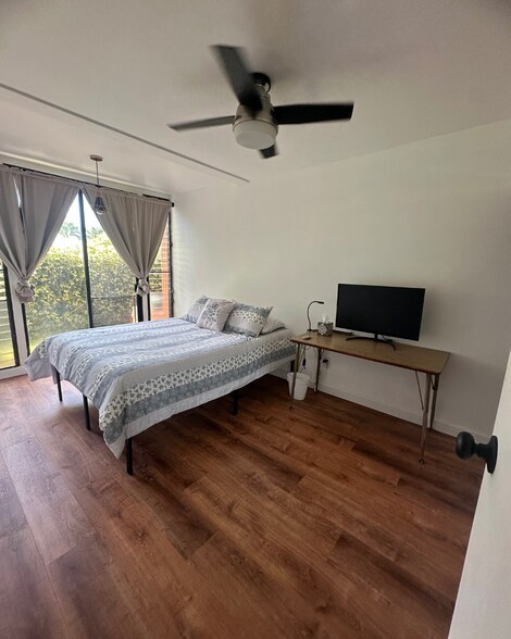 Bedroom 2 with Window AC, Ceiling Fan, and Glass Mirror sliding door closets. - 1107 Acacia Rd