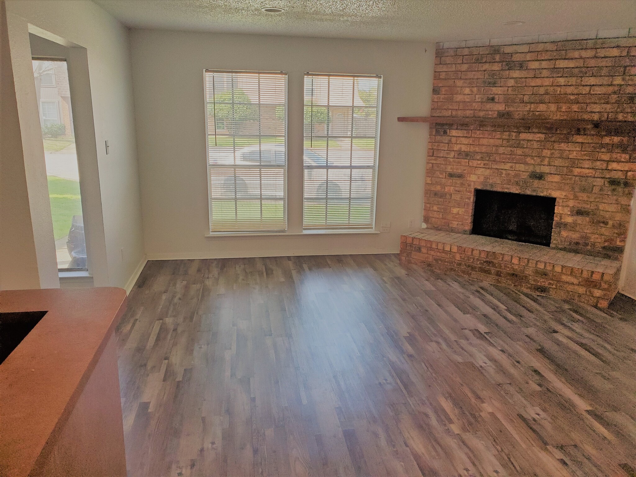 A warm welcoming HUGE living room with brand new floors.and a stunning roaring fireplace as its focal point. - 2205 Chase Ct