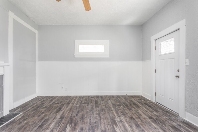 Front door entry into living room with ceiling fan. - 1150 Tecumseh St