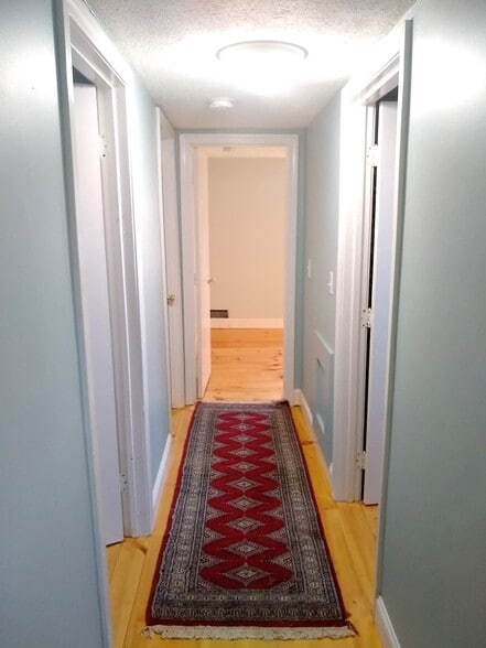 2nd floor hallway. Two bedrooms on the left. One bedroom at the end. Bathroom on the right. - 108 Mill Ln