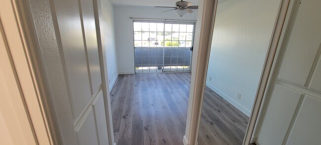 Master bedroom hallway with linen closet on left, closet on right, and balcony view - 14126 Tiara St
