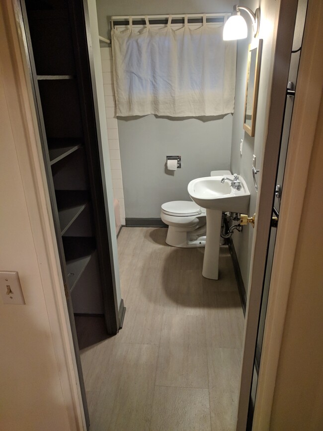 Full bathroom (tub and shower head) with shelving. - 4225 Sheffield Road