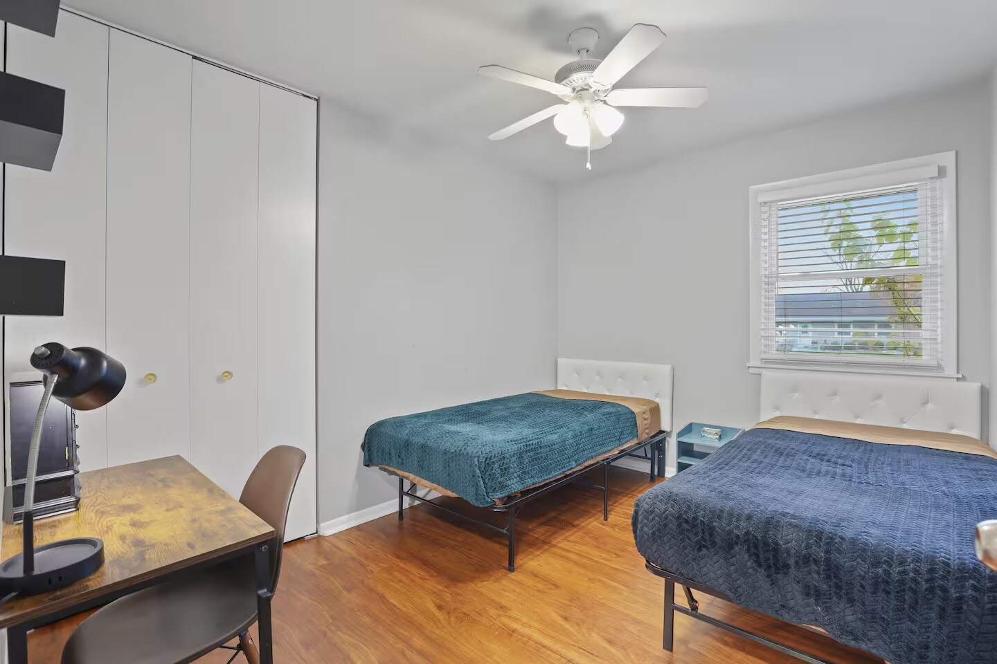 Bedroom 3 with 2 single beds, dedicated work space with table, lamp and chair and closet space. - 1002 Juniper Ln