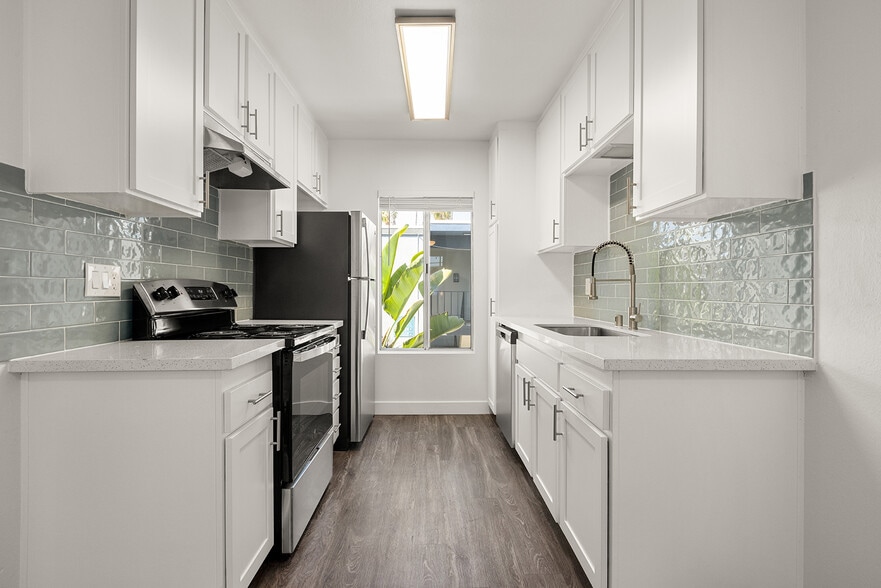Cook, dine, and gather in a stylish kitchen space. - Palms Apartments