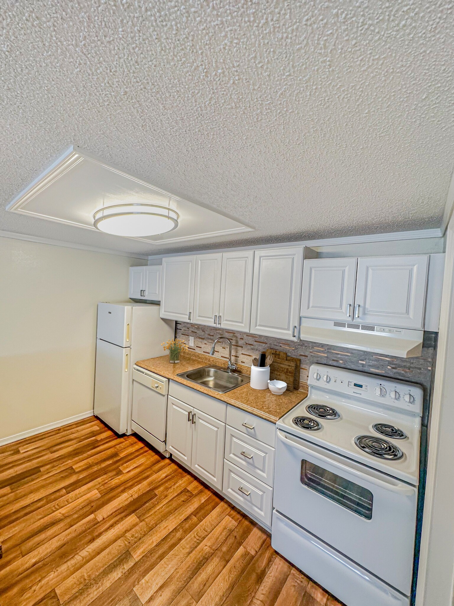 Prepare meals with ease in kitchens equipped with contemporary appliances, ample cabinetry, and functional layouts. - Whisperwood Apartments