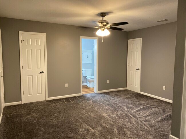 Upstairs bedroom with view of bathroom, closet and access to storage area - 1305 Cedar Shoals Drive #500