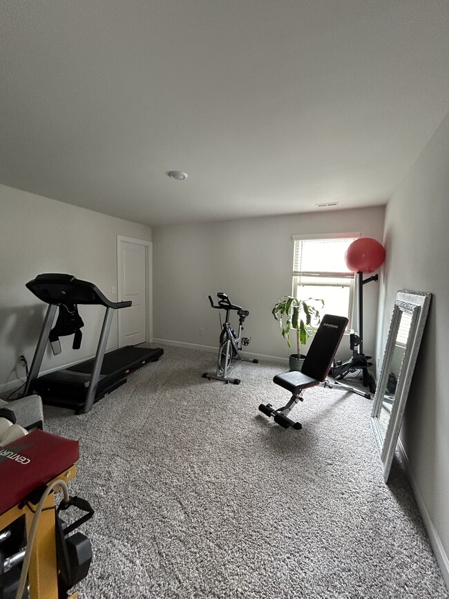 Upstairs bedroom 2, currently set up as a home gym. Walk-in closet - 4111 Honey Locust Dr