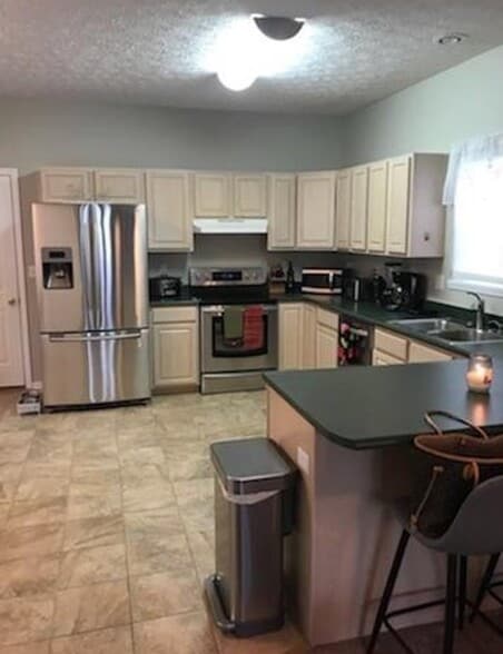 All stainless appliances in kitchen with a tile floor. Also has a full pantry. Eat in kitchen area. - 231 Legacy Lane