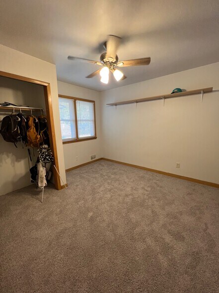Main floor bedroom with new carpet and ceiling fan installed in 2022. - 1060 21st Ave SE