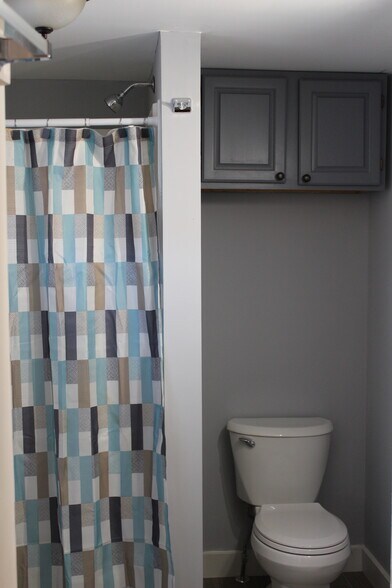Bathroom has large shower stall. Storage above toilet. - 1011 Main St