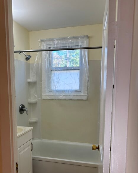 There is a clear shower curtain in front of the window. - 55 Gabrielle St