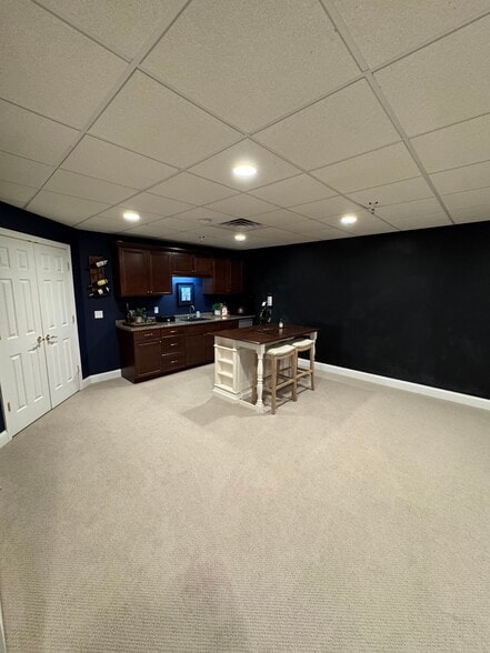 Basement includes bar with stools, as well as unfinished storage space behind double doors. - 270 Bella Ln