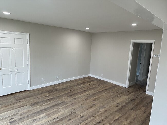 Living room with recessed lighting, front door entry, new baseboards, flooring, paint and thermostat - 4230 W 169th St