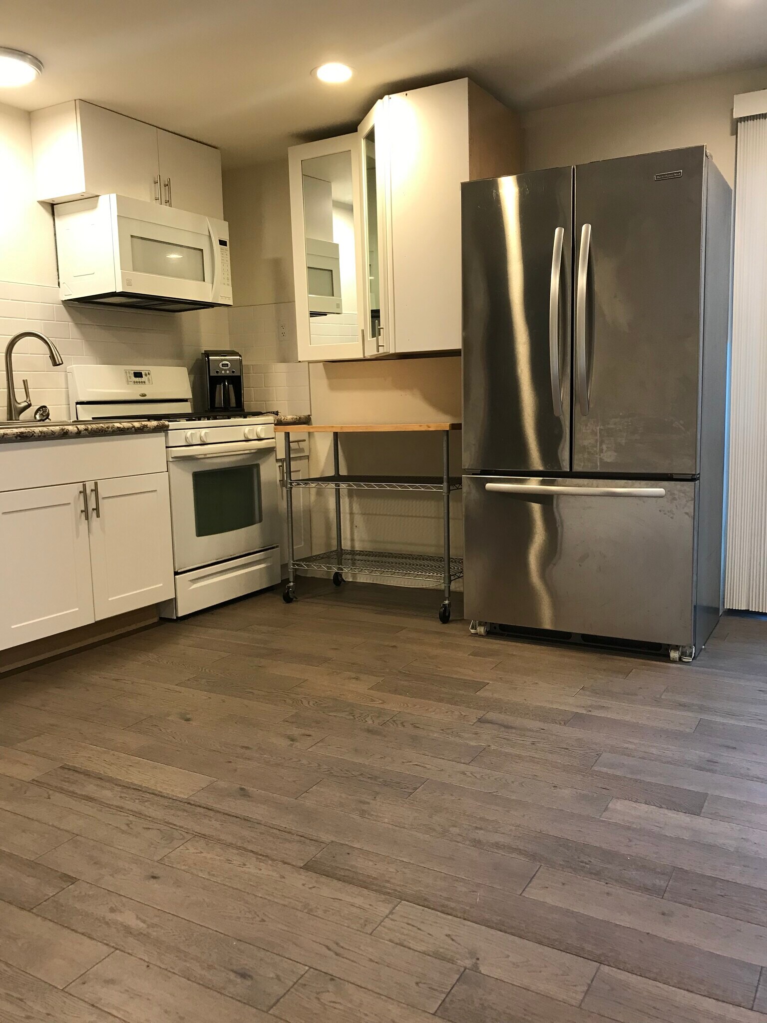 Modern kitchen with gas stove, granite island and stainless steel oversized refrigerator - 3412 177th Pl SW