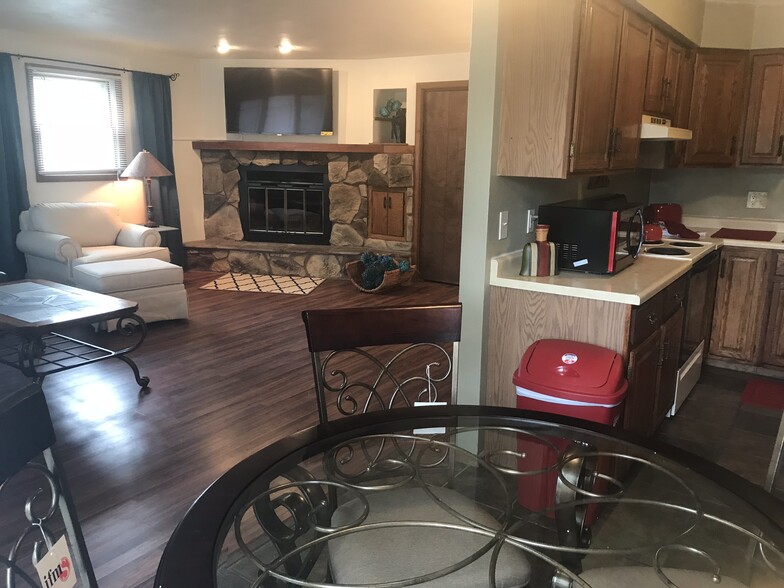 Open concept kitchen, dining and living areas allow the family to enjoy a real wood burning fire or watch TV while dining. - 502 Crab Apple Court