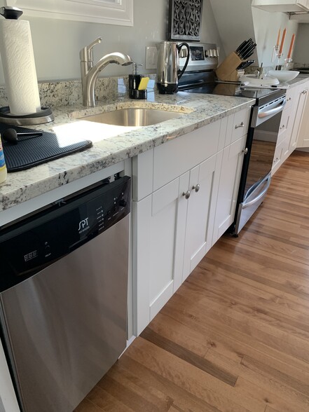 Kitchen area with new stainless steel appliances - dishwasher, garbage disposal, stove, microwave, Aire fryer/ toaster oven, full sized refrigerator. Lots of cabinets and draws with soft close. Granite counter tops. Hard wood floors. Numerous cabinets and crawl space storage available. - 97 Washington street