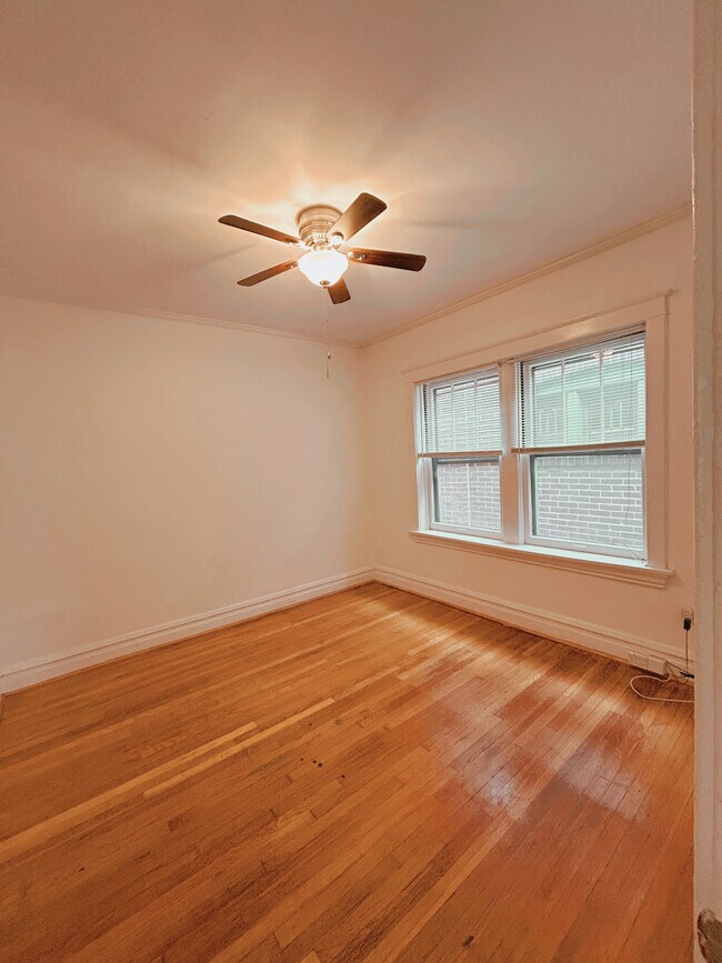 Bedroom #1 with hardwood floors, ceiling fan, and large windows - 2705 S Kingshighway Blvd