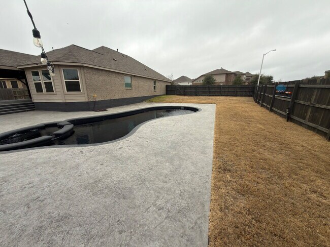 Building Photo - Four bed two bath on a corner lot with a pool in Sunfield. Gas cook top, double ovens. Open kitch...