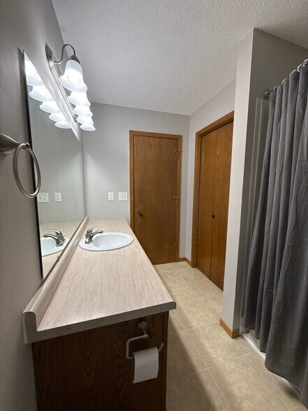 Upper bathroom featuring a long vanity and storage closet. - 9092 Goldenrod Ln N