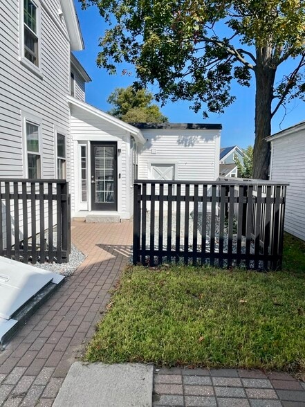 A view of the side yard and private mudroom entrance from the 2-car driveway. - 20 Chapel St